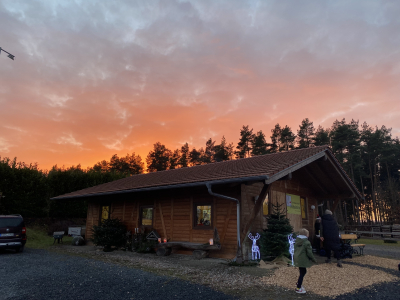 Rustikale Holzhütte im Christbaumdorf Klug bei Sonnenuntergang, Treffpunkt für Firmenweihnachtsfeiern im Spessart