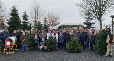Firmenausflug im Christbaumdorf Klug mit Gruppenfoto zwischen frisch gesägten Weihnachtsbäumen