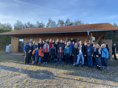 Firmenausflug zur Weihnachtsfeier im Christbaumdorf Klug mit Gruppenfoto vor der Holzhütte