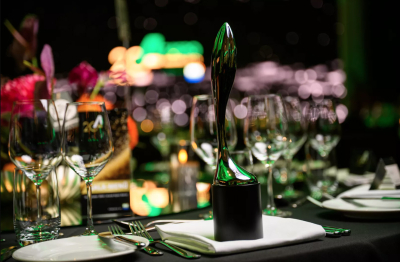 Taspo Award Trophäe 2025 auf festlich gedecktem Tisch mit Gläsern und Blumenschmuck bei der Preisverleihung in Berlin