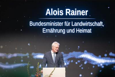 Alois Rainer spricht bei der Taspo Award Gala 2025 in Berlin am Rednerpult vor großem Bildschirm mit seinem Namen und Amtsbezeichnung als Bundesminister für Landwirtschaft Ernährung und Heimat
