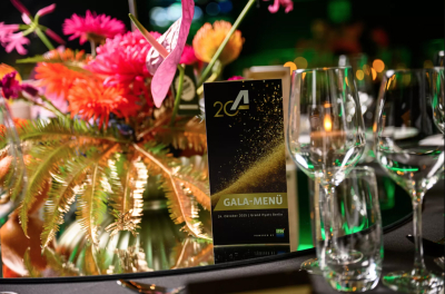 Gala Menü Karte der Taspo Award Verleihung 2025 im Grand Hyatt Berlin auf festlich gedecktem Tisch mit Gläsern und Blumenschmuck