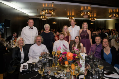 Mitglieder des Christbaumdorf Mittelsinn e. V. bei der Taspo Award Gala 2025 in Berlin sitzend und stehend an festlich gedecktem Tisch mit Blumenschmuck und guter Stimmung im Veranstaltungssaal