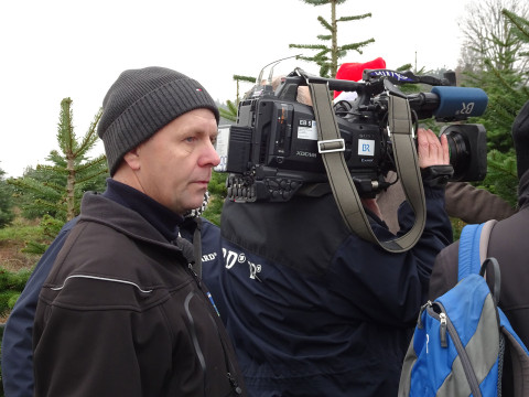 Nahaufnahme eines Kamerateams mit großer Fernsehkamera, ein Mann wird interviewt.