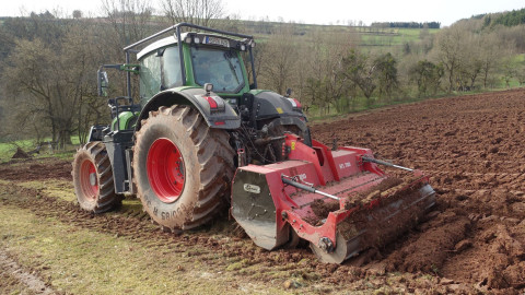 Traktor mit Fräse bei der Bodenbearbeitung vor neuer Weihnachtsbaumkultur