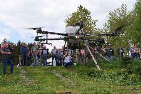 Demonstration von GPS-gesteuerter Drohne beim Boden-Kompetenz-Tag Große Drohne schwebt beim Start über einer Wiese, umgeben von zahlreichen Zuschauern und Bäumen